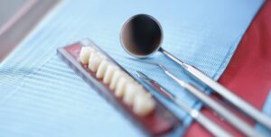 Orthodontist tools and dental bridge, close-up, blurry