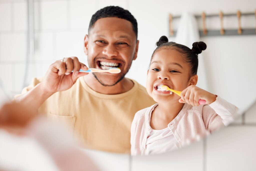 Child, dad and brushing teeth in a family home bathroom for dental health and wellness in a mirror